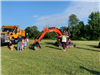 Parents and children in front of Public Works' machines