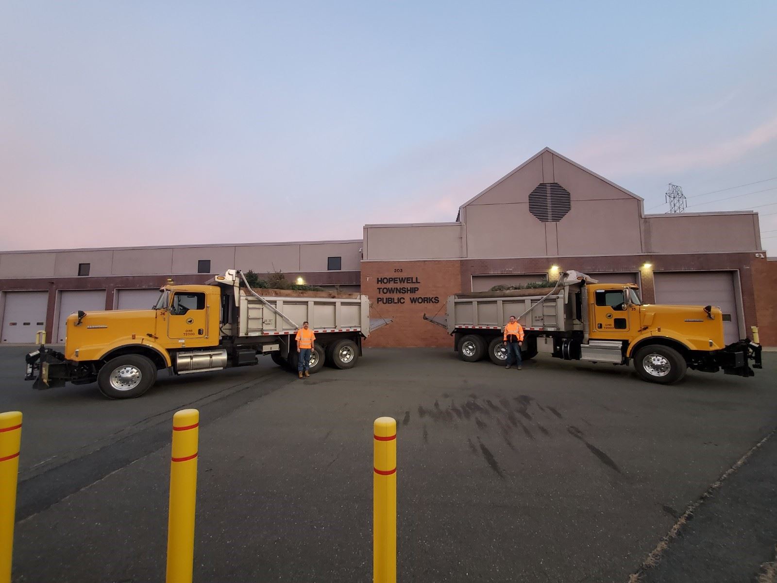 Public Works employees Al Re and Matt Reading in front of trucks filled with trees to be delivered