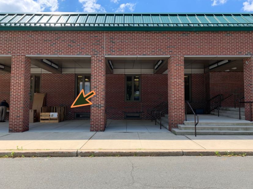 building with arrow pointing to food pantry bin