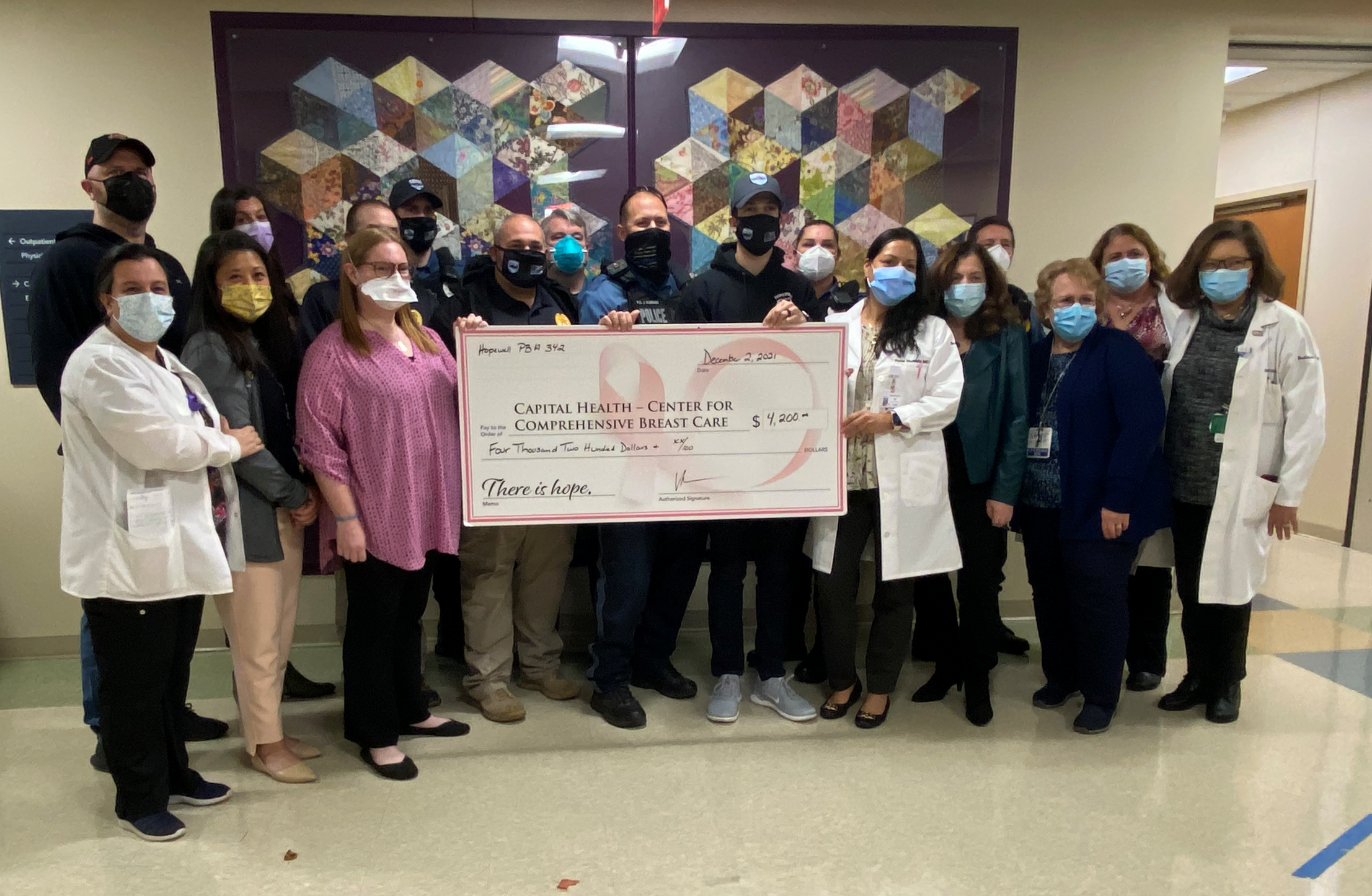 Police presenting charity football check for $4200 to Capital Health Breast Cancer Center